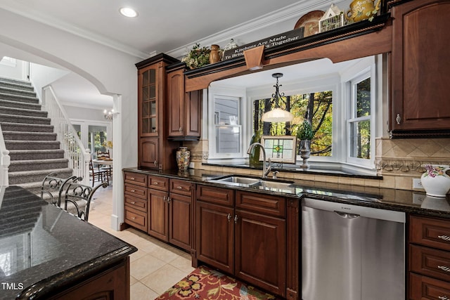 kitchen with dark stone counters, sink, stainless steel dishwasher, and plenty of natural light