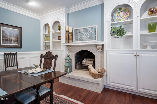 interior space featuring built in features, ornamental molding, dark hardwood / wood-style floors, and a brick fireplace