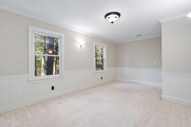 spare room featuring ornamental molding, light colored carpet, and a healthy amount of sunlight