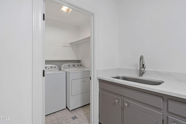 clothes washing area with separate washer and dryer and sink