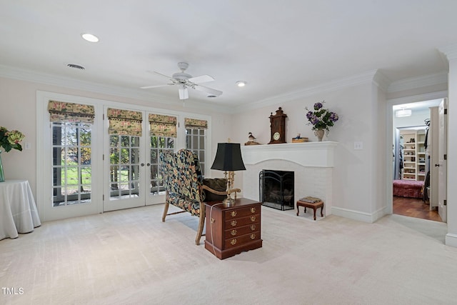 carpeted living room featuring crown molding, a fireplace, ceiling fan, and french doors