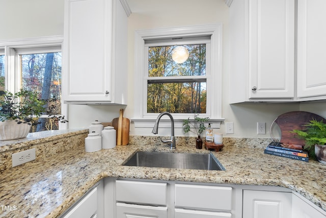 kitchen featuring a wealth of natural light, sink, and white cabinets