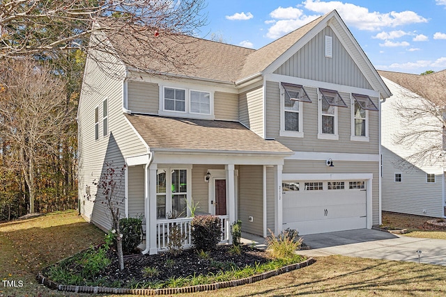 view of front of property featuring a front yard, a garage, and covered porch