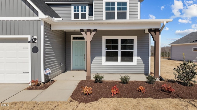 view of exterior entry with an attached garage, board and batten siding, and roof with shingles