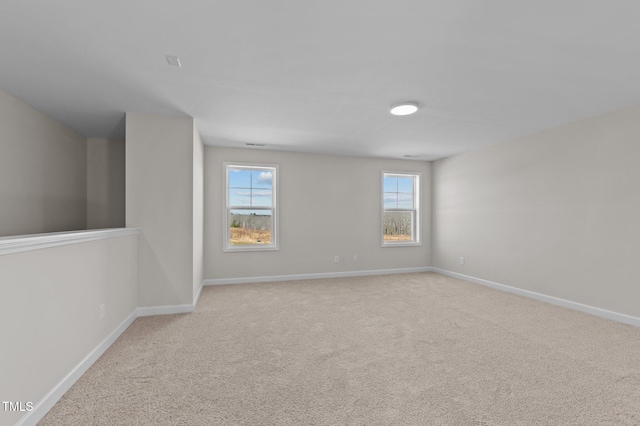 spare room with light colored carpet and baseboards