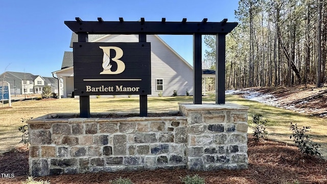 community / neighborhood sign with a yard