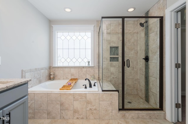 bathroom featuring tile patterned floors, vanity, and shower with separate bathtub