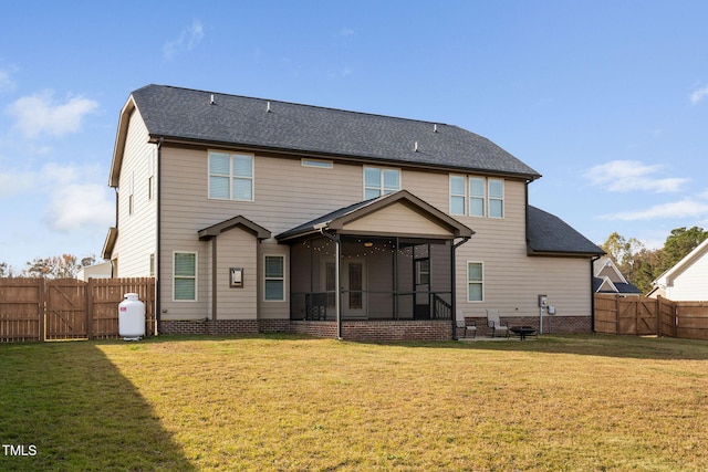 rear view of property with a yard and a sunroom