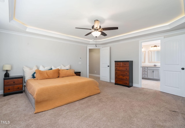 carpeted bedroom featuring a tray ceiling, ensuite bath, ceiling fan, and sink