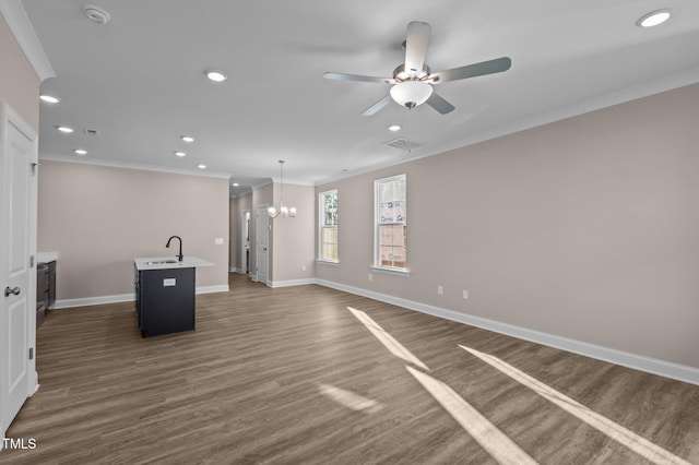 unfurnished living room featuring crown molding, dark hardwood / wood-style flooring, ceiling fan with notable chandelier, and sink