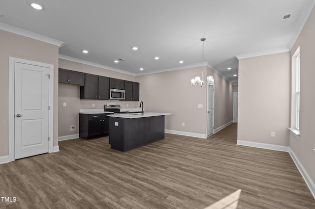 kitchen featuring sink, a notable chandelier, pendant lighting, a center island with sink, and appliances with stainless steel finishes