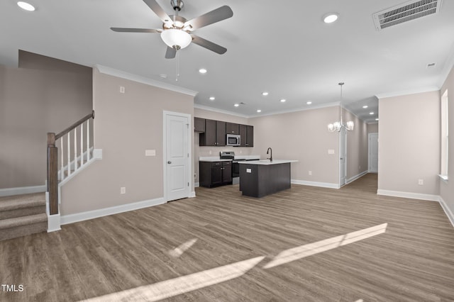 kitchen with crown molding, light wood-type flooring, an island with sink, appliances with stainless steel finishes, and decorative light fixtures