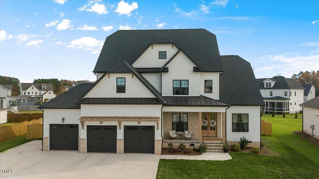 view of front facade featuring a front yard, a garage, and a porch