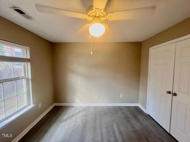 unfurnished bedroom featuring ceiling fan, a closet, and dark hardwood / wood-style floors