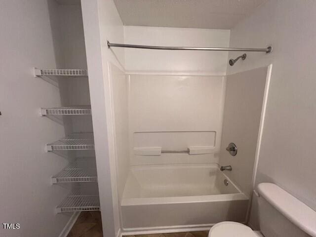 bathroom featuring shower / bathtub combination and toilet