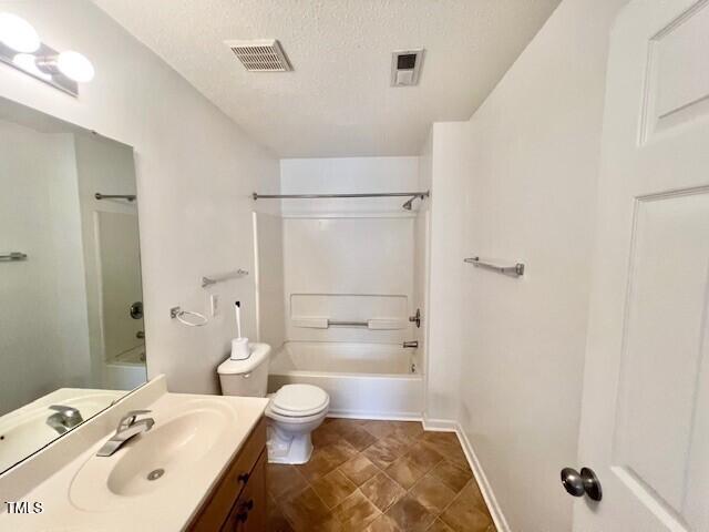 full bathroom with vanity, tub / shower combination, toilet, and a textured ceiling