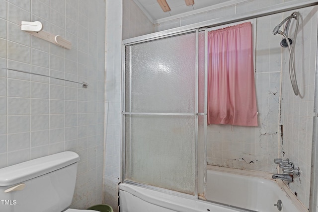 bathroom with toilet, tile walls, crown molding, and enclosed tub / shower combo