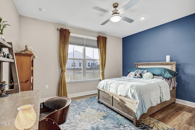 bedroom with a ceiling fan, baseboards, and wood finished floors