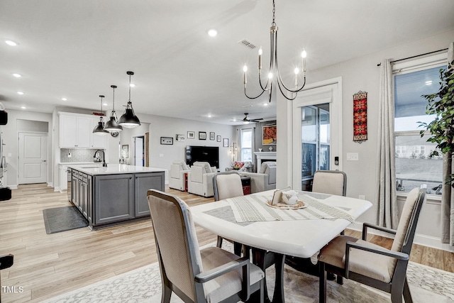 dining room with a fireplace, recessed lighting, visible vents, light wood-style floors, and a ceiling fan