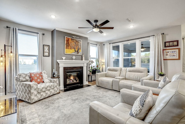 living area with a high end fireplace, visible vents, ceiling fan, and recessed lighting