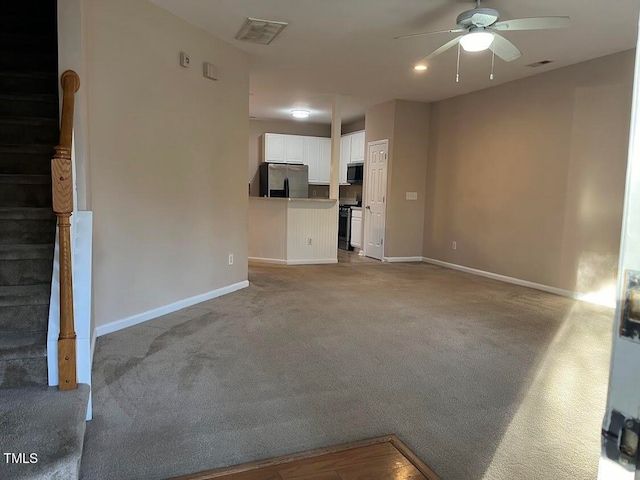 unfurnished living room with ceiling fan and light colored carpet