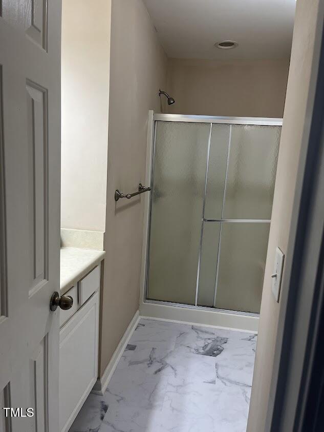 bathroom featuring vanity and a shower with door