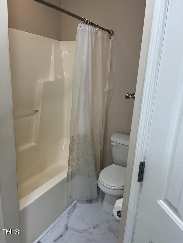 bathroom with toilet and shower / bathtub combination with curtain