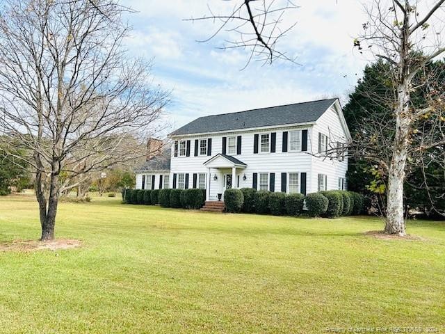 colonial inspired home featuring a front lawn