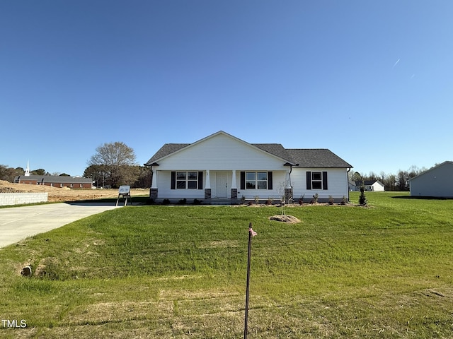 view of front facade featuring roof with shingles and a front yard