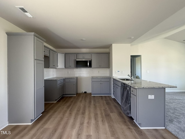 kitchen with light stone countertops, visible vents, stainless steel appliances, gray cabinetry, and backsplash