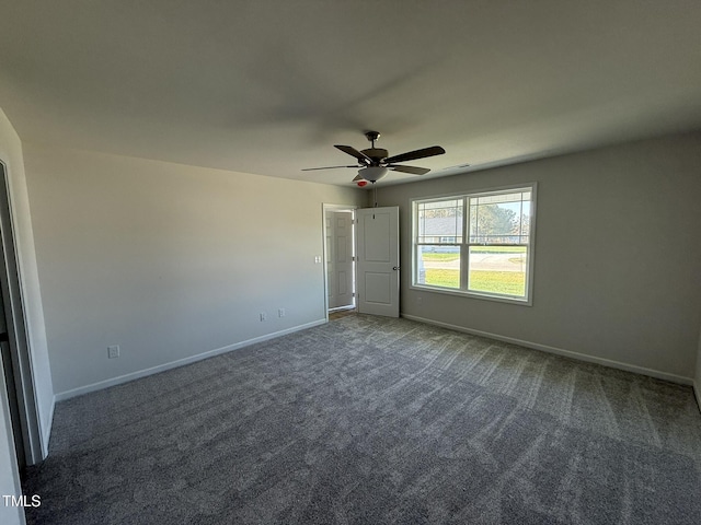 carpeted spare room with baseboards and a ceiling fan