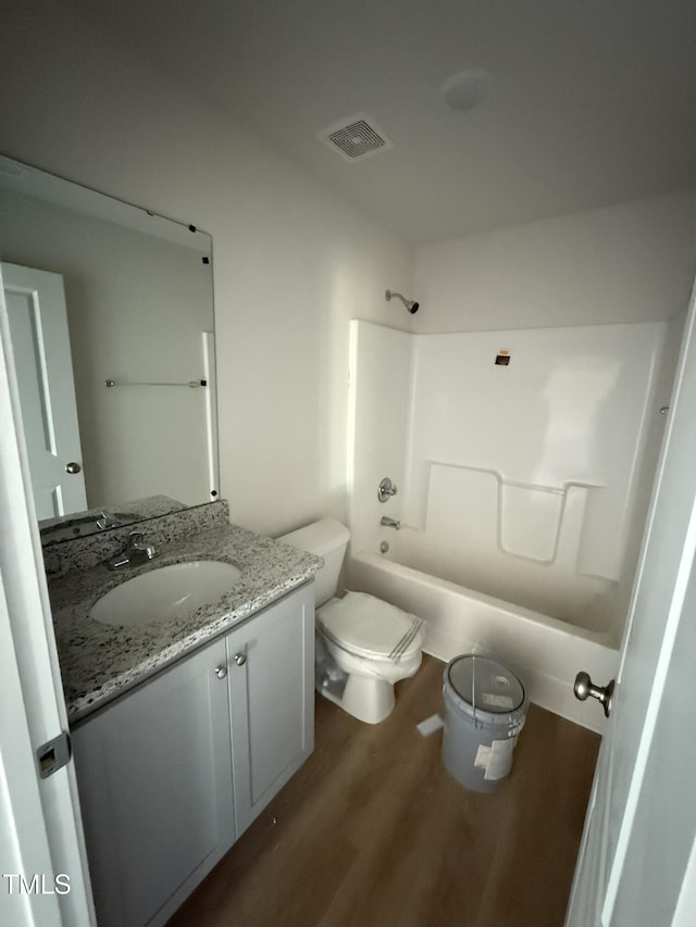 full bathroom with vanity, shower / tub combination, visible vents, toilet, and wood finished floors