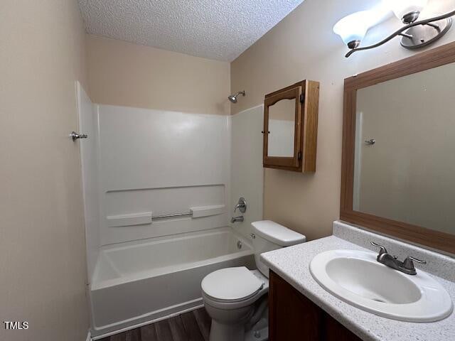 full bathroom featuring vanity, toilet, a textured ceiling, wood-type flooring, and tub / shower combination