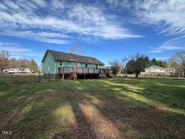 rear view of house with a lawn and a wooden deck