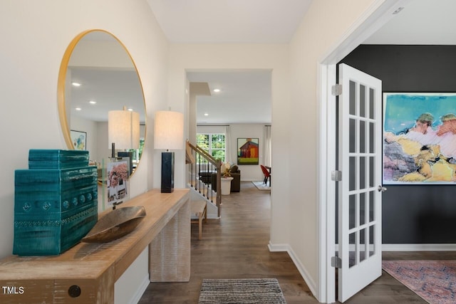 hall featuring wood finished floors, baseboards, stairway, and recessed lighting