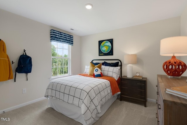 bedroom with baseboards and light colored carpet
