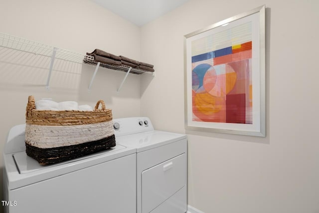 washroom with washer and clothes dryer and baseboards