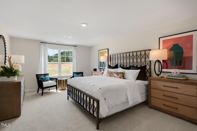 bedroom with light colored carpet and baseboards