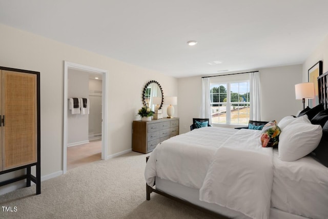 carpeted bedroom featuring baseboards and connected bathroom