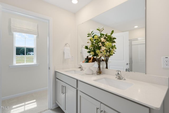 bathroom with double vanity, an enclosed shower, recessed lighting, and baseboards