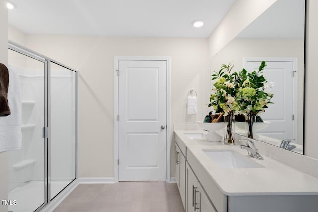bathroom with a stall shower, double vanity, tile patterned floors, baseboards, and recessed lighting