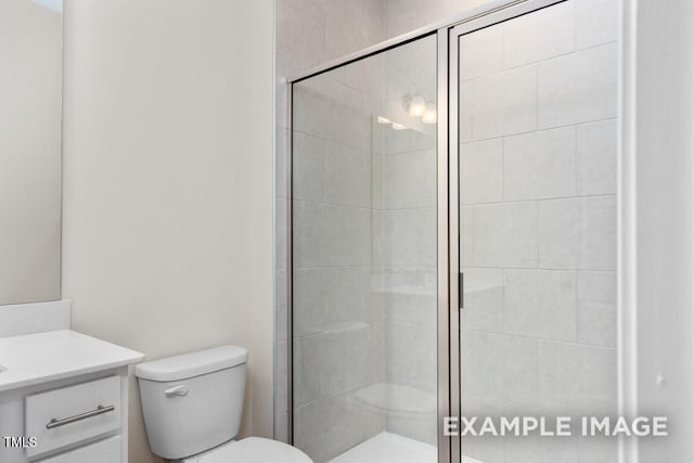 bathroom with vanity, a shower with door, and toilet