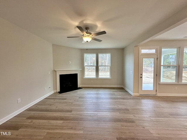 unfurnished living room with a healthy amount of sunlight, ceiling fan, and light hardwood / wood-style flooring