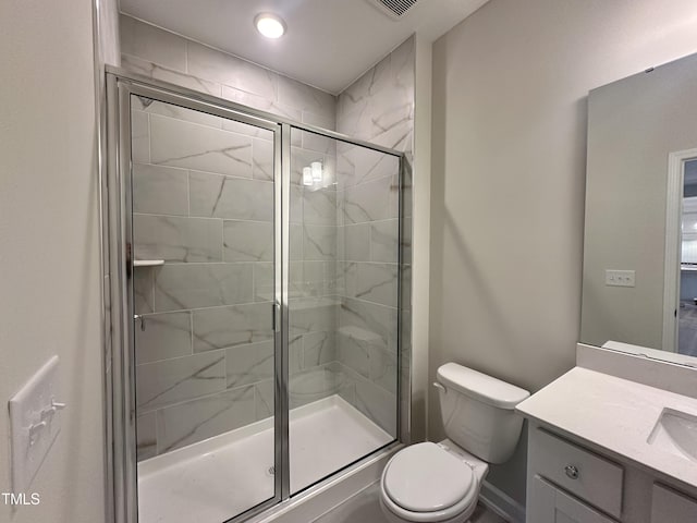 bathroom with vanity, toilet, and a shower with shower door