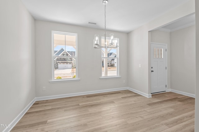 unfurnished dining area featuring an inviting chandelier, light wood-style flooring, visible vents, and baseboards