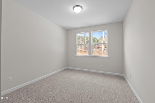 carpeted empty room featuring baseboards