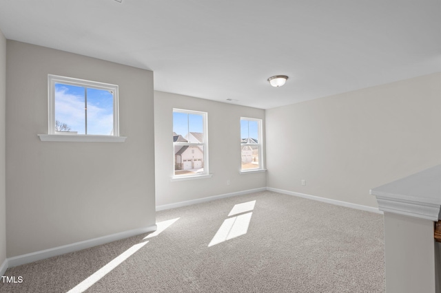 spare room featuring carpet and baseboards