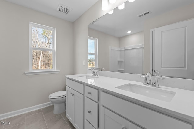 bathroom featuring toilet, a sink, and visible vents