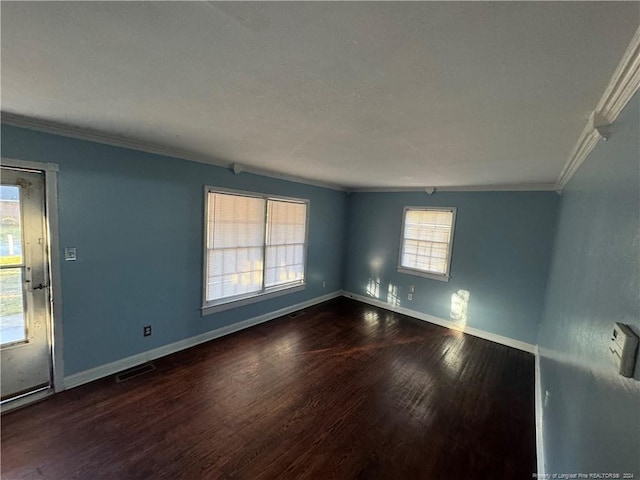 spare room featuring dark hardwood / wood-style floors and ornamental molding