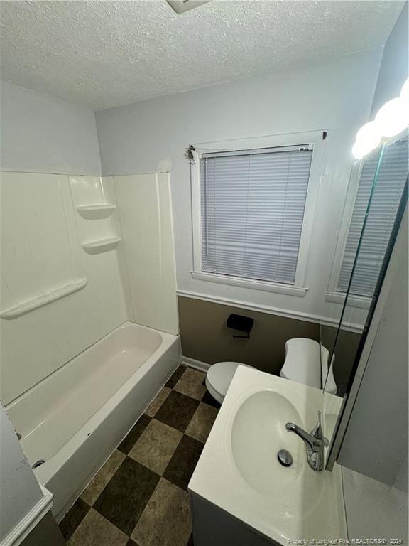 full bathroom with shower / washtub combination, vanity, a textured ceiling, and toilet